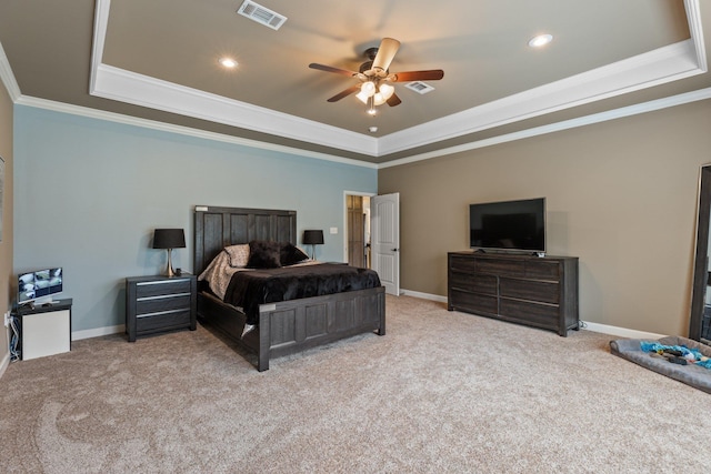 bedroom featuring a tray ceiling, carpet flooring, visible vents, and crown molding