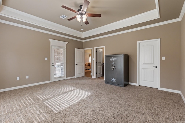 unfurnished bedroom featuring a tray ceiling, ornamental molding, carpet flooring, and baseboards