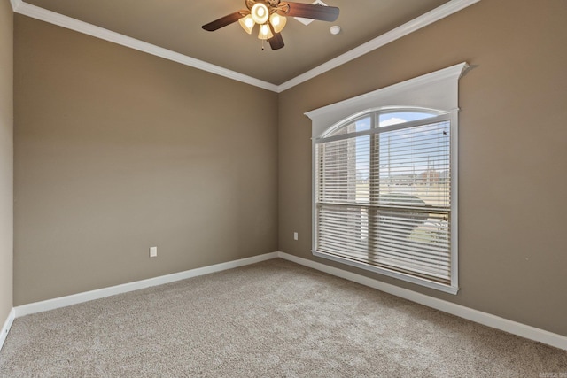 carpeted empty room featuring baseboards, ceiling fan, and crown molding