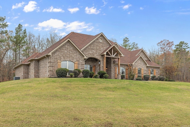 view of front facade featuring central air condition unit, brick siding, and a front yard