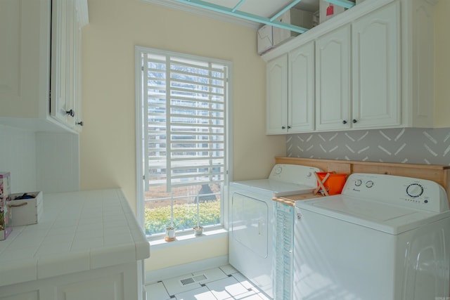 laundry area featuring baseboards, cabinet space, visible vents, and washing machine and clothes dryer