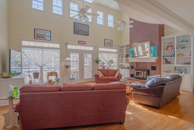 living room with light wood finished floors, a ceiling fan, and a wealth of natural light