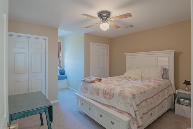 bedroom with light carpet, a ceiling fan, visible vents, and baseboards