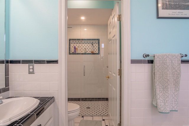 full bathroom featuring tile patterned flooring, toilet, vanity, tile walls, and a shower stall