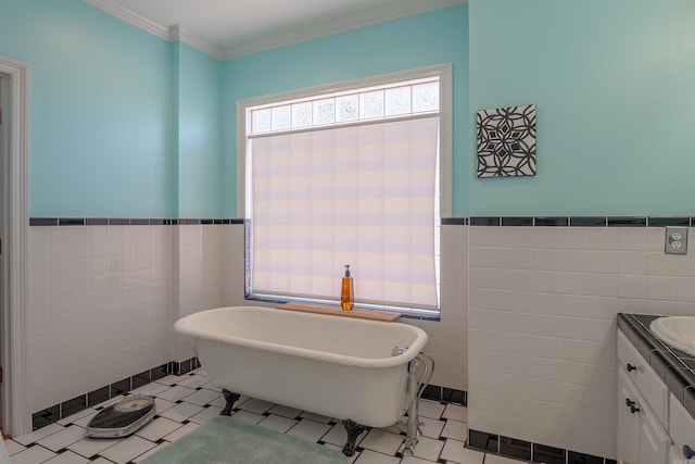 bathroom with ornamental molding, a freestanding bath, tile walls, and vanity