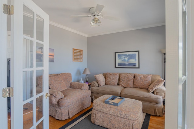 living room featuring light wood-style floors, ceiling fan, crown molding, and french doors