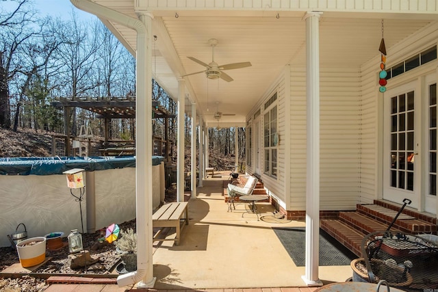 view of patio / terrace with a covered pool and ceiling fan