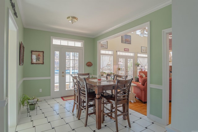 dining space with baseboards, ornamental molding, and french doors