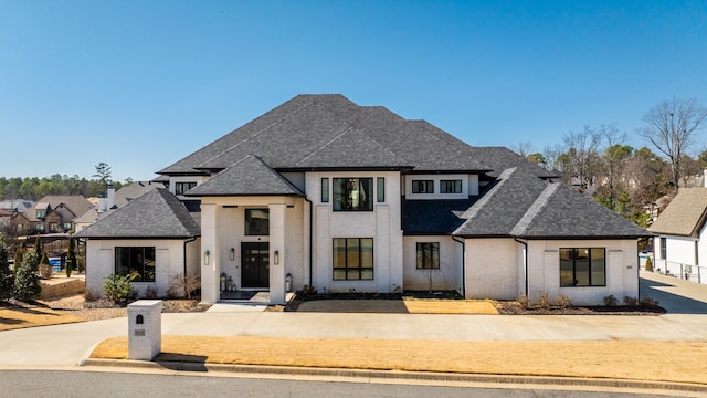 french country home with roof with shingles