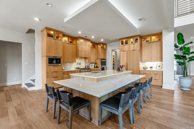 108 Mornay Ln, Little Rock, AR 72223 - kitchen featuring a breakfast bar area, light wood-type flooring, and a large island with sink