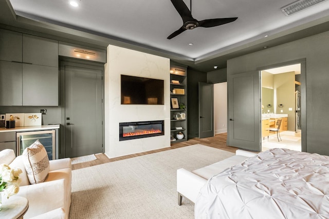 108 Mornay Ln, Little Rock, AR 72223 - bedroom featuring wine cooler, visible vents, a glass covered fireplace, and light wood finished floors