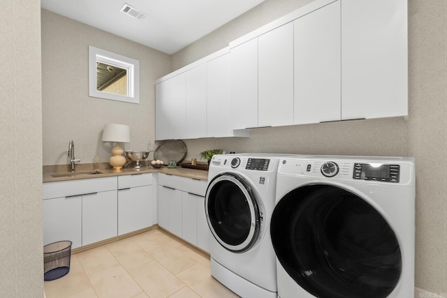 108 Mornay Ln, Little Rock, AR 72223 - laundry area with light tile patterned floors, cabinet space, visible vents, washing machine and dryer, and a sink