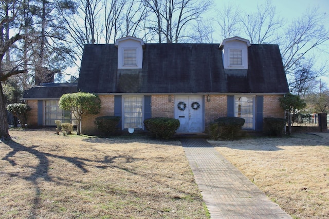 view of front of property featuring roof with shingles and brick siding