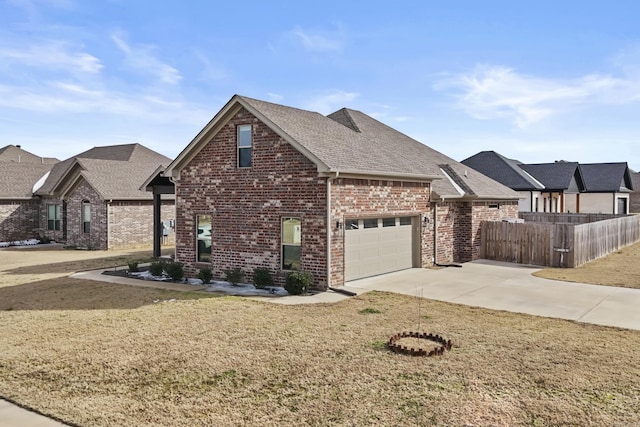 view of front of house with brick siding, concrete driveway, an attached garage, fence, and a front yard