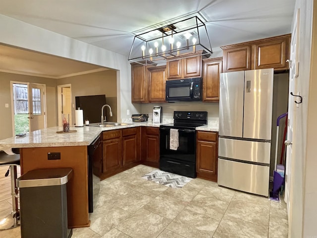 kitchen with brown cabinetry, a breakfast bar, a peninsula, black appliances, and a sink