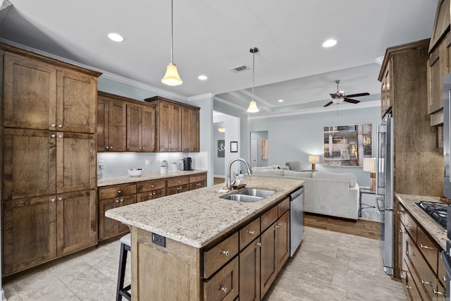 kitchen with stainless steel appliances, visible vents, decorative backsplash, open floor plan, and a sink