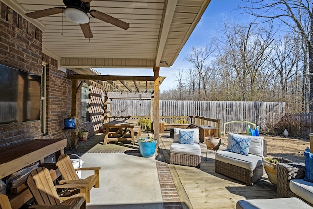 view of patio / terrace featuring a fenced backyard, an outdoor hangout area, a ceiling fan, and outdoor dining space