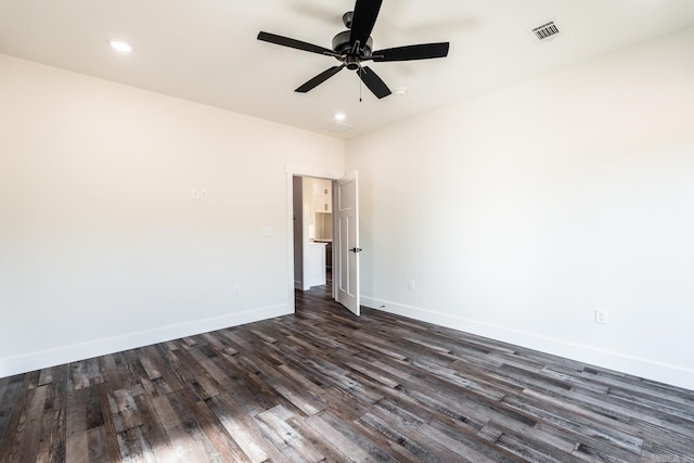 spare room featuring recessed lighting, dark wood-type flooring, a ceiling fan, visible vents, and baseboards