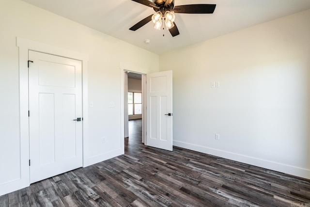 unfurnished bedroom with a ceiling fan, baseboards, and dark wood-style flooring