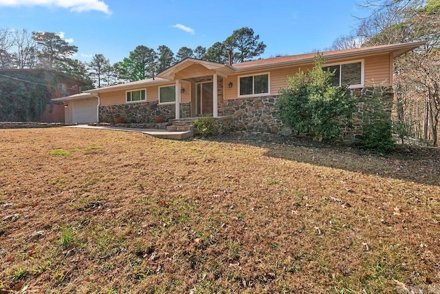 ranch-style house featuring stone siding, a front lawn, and an attached garage