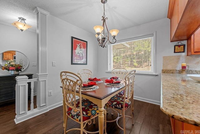 dining area featuring dark wood-style floors, a textured ceiling, baseboards, and a notable chandelier