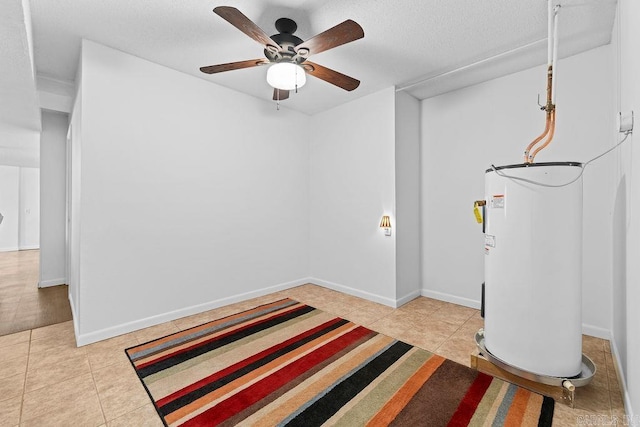 interior space with electric water heater, ceiling fan, baseboards, and light tile patterned floors