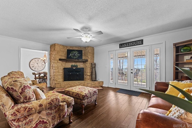 living room with dark wood-style floors, french doors, ornamental molding, ceiling fan, and a textured ceiling