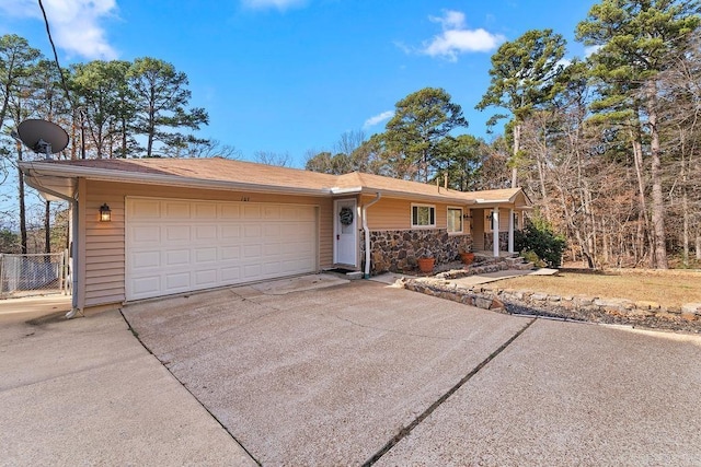 ranch-style home featuring stone siding, an attached garage, fence, and driveway