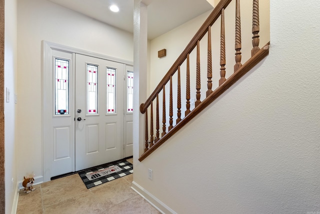 tiled entrance foyer with stairs, recessed lighting, and baseboards