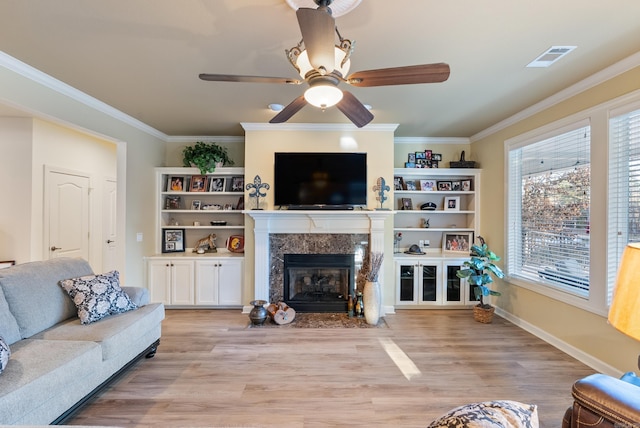 living area featuring ornamental molding, a wealth of natural light, and a premium fireplace