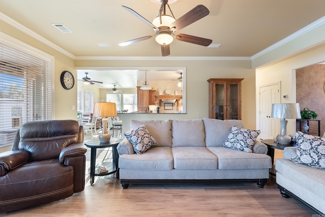 living room featuring visible vents, ornamental molding, and wood finished floors