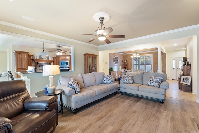 living room featuring light wood-type flooring, ornate columns, crown molding, and ceiling fan with notable chandelier