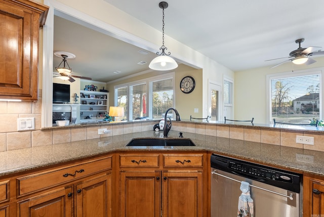 kitchen featuring stainless steel dishwasher, a sink, and brown cabinets