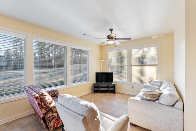 living room with light tile patterned floors, visible vents, a ceiling fan, and baseboards