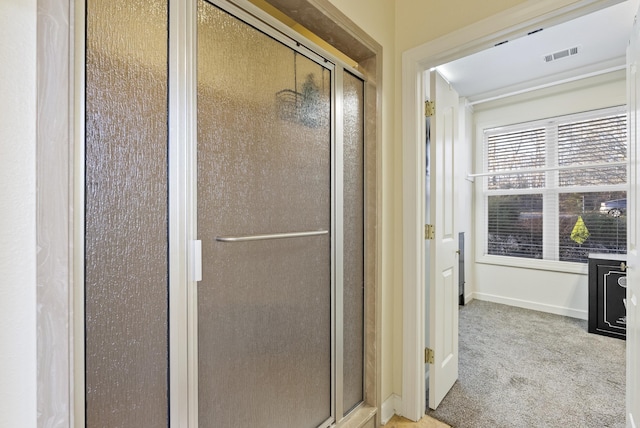 bathroom featuring a shower stall, visible vents, and baseboards