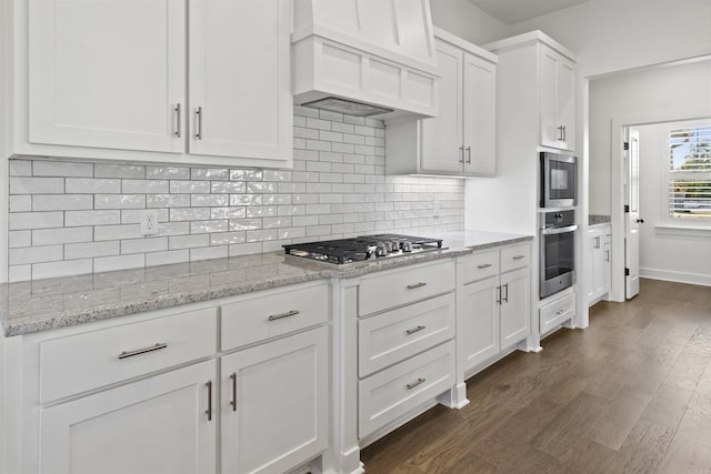 kitchen featuring white cabinetry, custom range hood, and stainless steel gas cooktop