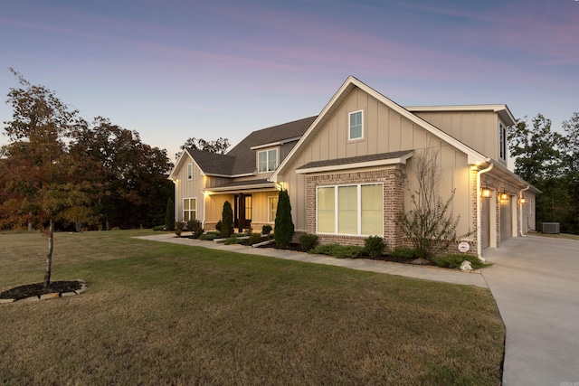 view of front of home featuring board and batten siding, a front yard, concrete driveway, and brick siding