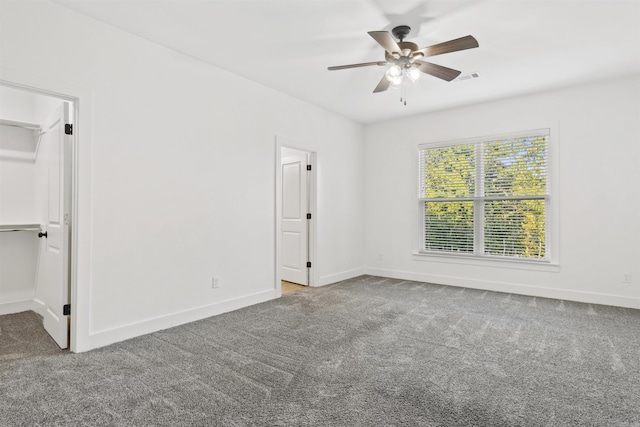 unfurnished bedroom with carpet, visible vents, a spacious closet, and baseboards