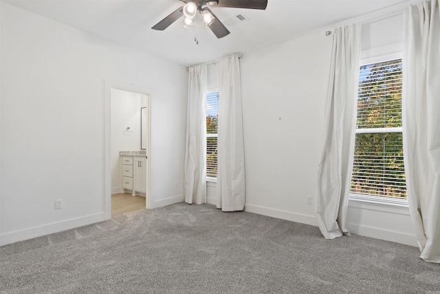 unfurnished bedroom with light colored carpet, visible vents, baseboards, and multiple windows