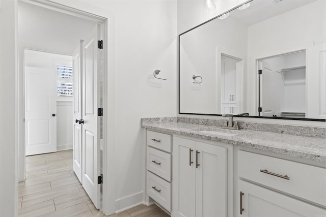 bathroom featuring baseboards, vanity, and wood tiled floor