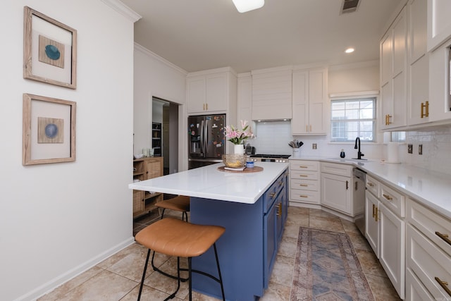 kitchen with a breakfast bar area, visible vents, blue cabinetry, appliances with stainless steel finishes, and backsplash