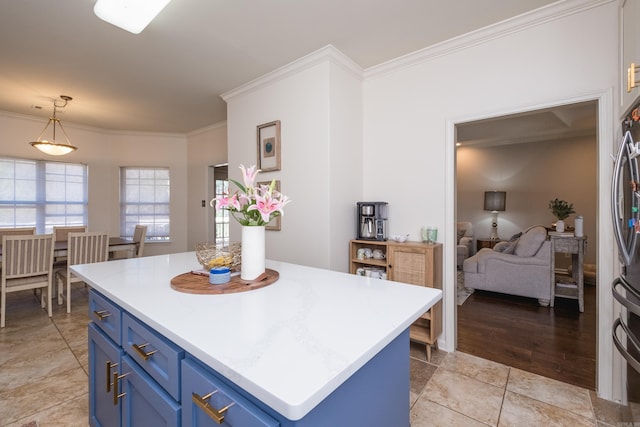 kitchen featuring blue cabinets, light countertops, ornamental molding, and hanging light fixtures