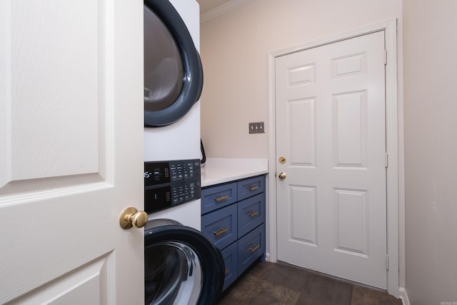 clothes washing area with cabinet space and stacked washing maching and dryer