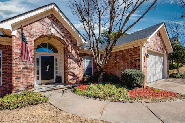 view of front of property featuring concrete driveway, brick siding, and an attached garage