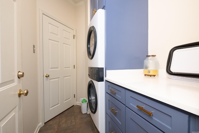 laundry room with cabinet space and stacked washer and clothes dryer