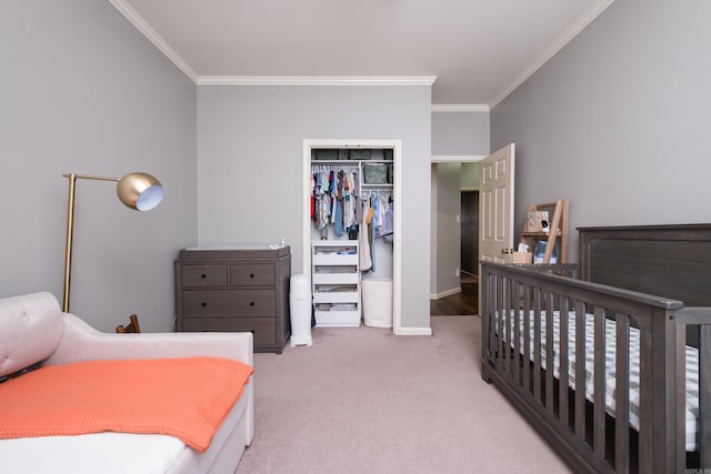 carpeted bedroom featuring baseboards, ornamental molding, and a closet