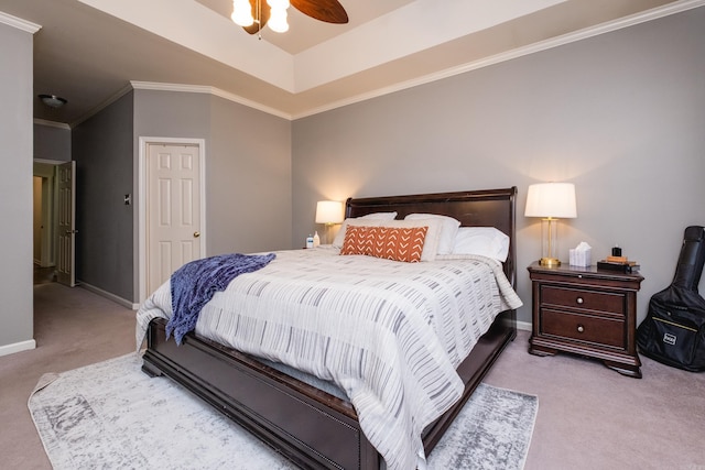 bedroom with baseboards, a raised ceiling, a ceiling fan, crown molding, and carpet flooring