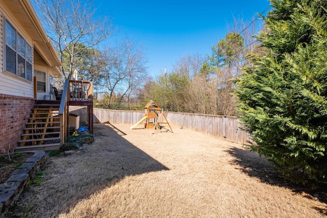 exterior space with a fenced backyard, stairs, and a playground