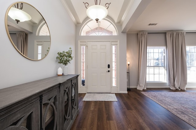 entrance foyer with dark wood-style flooring, visible vents, crown molding, and baseboards