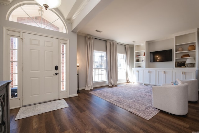 entryway featuring baseboards, visible vents, dark wood finished floors, and ornamental molding